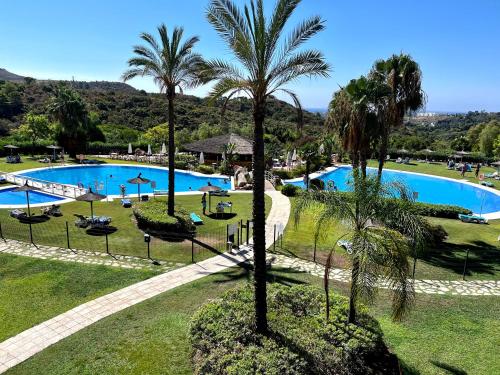 Blick auf den Pool in einem Resort mit Palmen in der Unterkunft VILLA rosa BENAHAVIS in Estepona