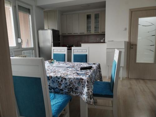 a kitchen with a table and chairs with a table and a table at Downtown penthouse Šabac in Šabac
