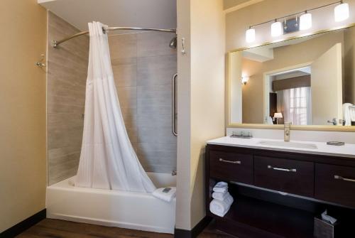 uma casa de banho com um chuveiro e um lavatório. em Best Western Syracuse Downtown Hotel and Suites em Syracuse