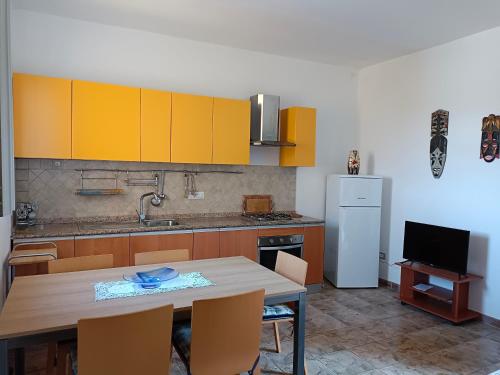Pabillonis的住宿－CASA ZENOBIO，厨房配有黄色橱柜和桌椅