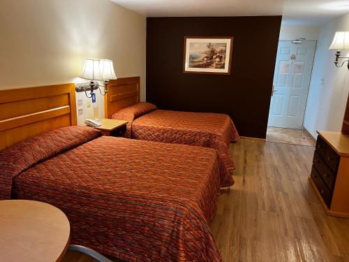 a hotel room with two beds and a table at Hotel Oliver Inn Toluca in Toluca