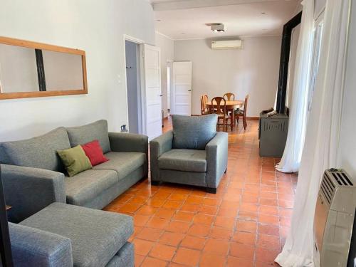 sala de estar con sofá, 2 sillas y mesa en Hermosa casa céntrica, menos en euro usd en San Antonio de Areco