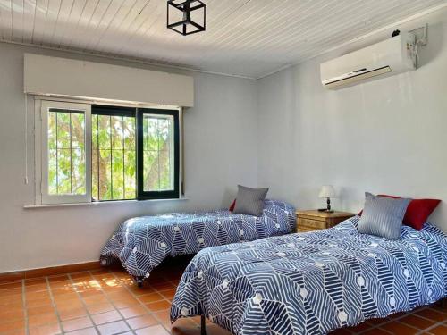 ein Schlafzimmer mit zwei Betten und einem Fenster in der Unterkunft Hermosa casa céntrica in San Antonio de Areco