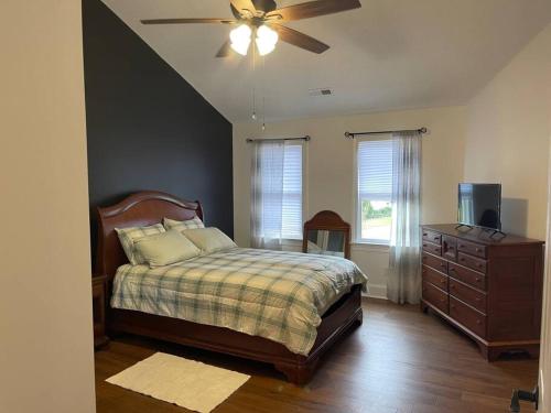 Newly Renovated home in A Beautiful Peaceful Neighborhood في Winterville: غرفة نوم بسرير ومروحة سقف