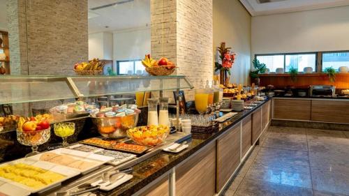 una línea de buffet en una habitación de hotel con comida en Flat Beach Class Executive, en Recife