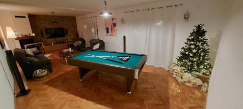 a living room with a pool table and a christmas tree at Villa Sorella Baranja in Karanac