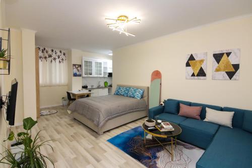 sala de estar con sofá azul y cama en Nazari Apartment 1, en Tirana