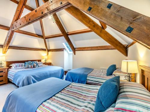 2 bedden in een kamer met houten plafonds bij Puffin Cottage - Uk42131 in Bamburgh