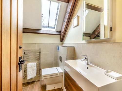 een badkamer met een wastafel, een toilet en een spiegel bij Puffin Cottage - Uk42131 in Bamburgh