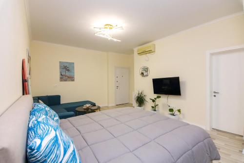 um quarto com uma cama grande e um sofá em Nazari Apartment 1 em Tirana