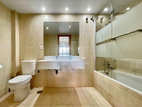 a bathroom with a toilet and a sink and a shower at Apartment near beach with pools and hot tub in Los Amarguillos