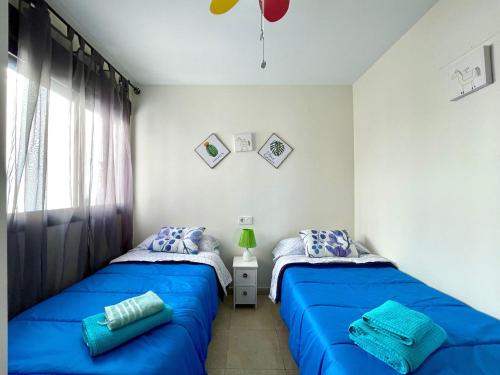 2 Betten in einem Schlafzimmer mit blauer Bettwäsche in der Unterkunft Premium apartment in Carboneras with relaxation area in Carboneras