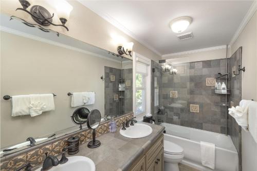 a bathroom with two sinks and a tub and a toilet at 3813 Point Break home in Pacific Grove