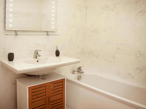 une salle de bain blanche avec un lavabo et une baignoire dans l'établissement Apartment in Macinaggio by the Marina, à Rogliano