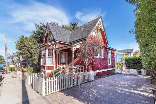 a red house with a white fence on a street at 3812 Little House home in Pacific Grove