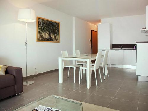 un salon avec une table et des chaises blanches dans l'établissement Apartment in Macinaggio by the Marina, à Rogliano