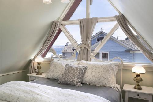 1 dormitorio con cama y ventana grande en 3812 Little House home, en Pacific Grove