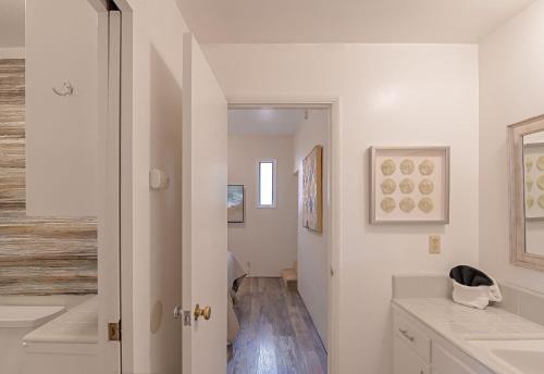 カーメルにある3797 Pine Place aptsの白い壁のバスルーム、洗面台付きの廊下