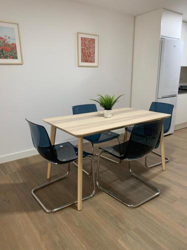 a wooden table with chairs and a potted plant on it at Apartamento Central D in Algeciras