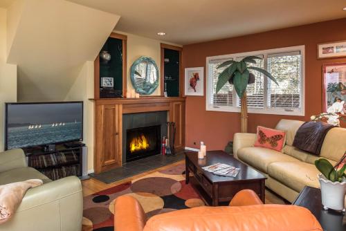 a living room with a fireplace and a tv at 3743 Pelican Peaks home in Pacific Grove