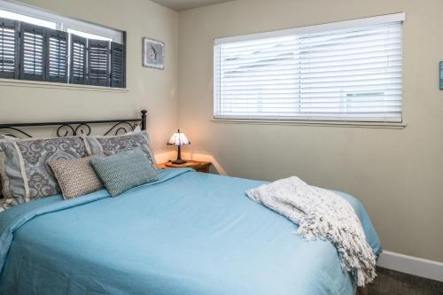 ein Schlafzimmer mit einem blauen Bett und einem Fenster in der Unterkunft 3804 Mermaid Loft home in Pacific Grove