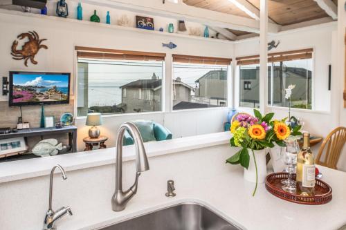 eine Küche mit einem Waschbecken und einem Tresen mit Blumen in der Unterkunft 3804 Mermaid Loft home in Pacific Grove