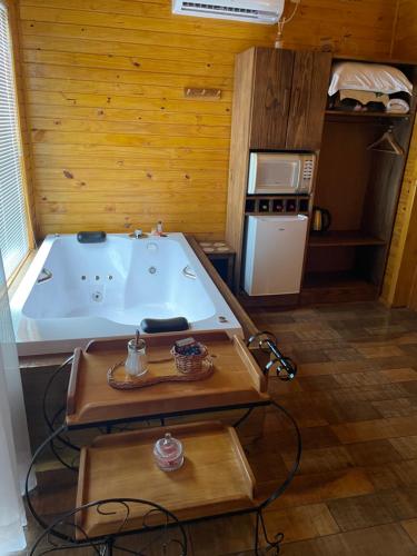 baño con bañera y cocina con nevera. en Pousada Recanto Das Araucárias en Bocaina do Sul