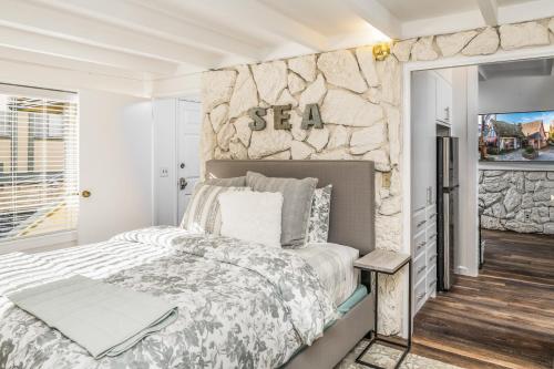 1 dormitorio con cama y pared de piedra en 3798 Cedar Place apts, en Carmel