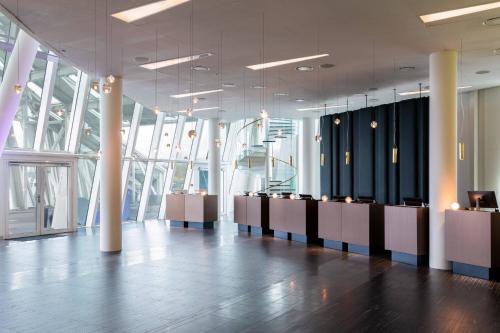 a lobby with a row of desks and windows at AC Hotel by Marriott Bella Sky Copenhagen in Copenhagen