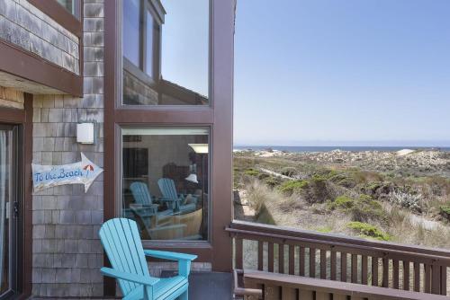a pair of blue chairs sitting on a porch looking out at the ocean at 3823 Sand Dollar House condo in Castroville