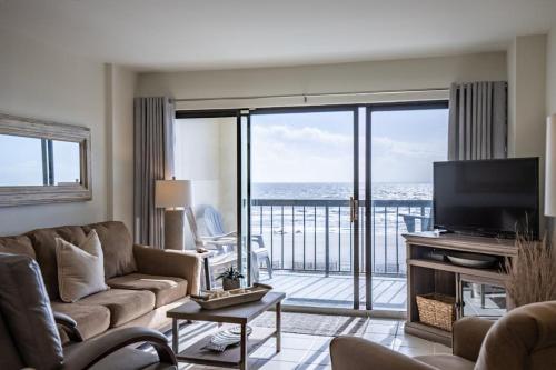 a living room with a couch and a view of the ocean at Captivating OceanFront Views@Crescent Towers II*Pool*Grills* in Myrtle Beach
