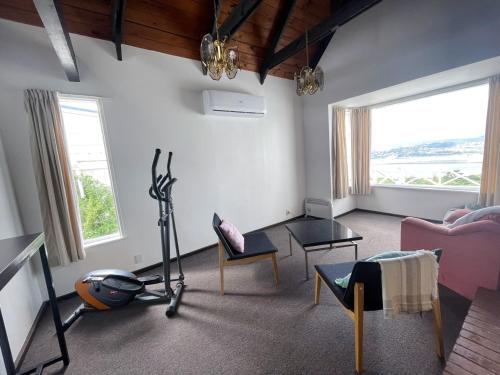 a living room with a room with a treadmill and chairs at NO PARTY ALLOWED,Sea view 5 bedroom house in Wellington