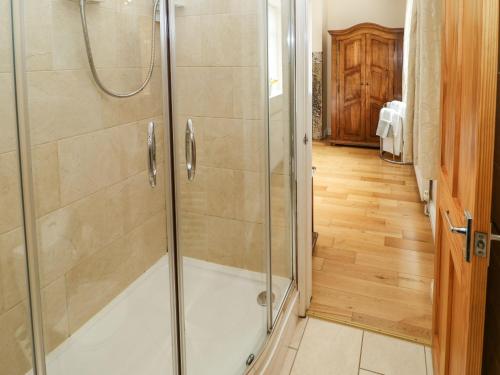 a shower with a glass door in a bathroom at Houghton North Farm Cottage in Heddon on the Wall
