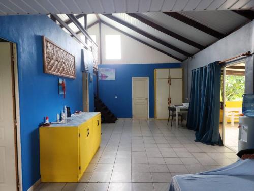 Habitación con encimera amarilla y pared azul en VILLA DE LA BAIE RAIATEA en Uturoa