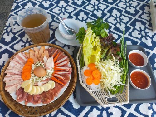 uma mesa com dois pratos de comida e uma bebida em นอนนิ่ง อิงดาว em Ban Pha Sai