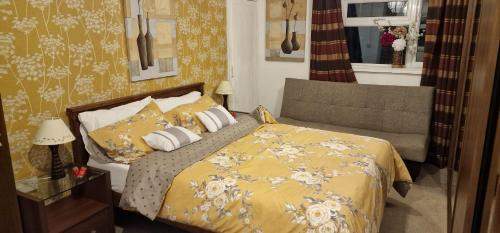 a bedroom with a bed with a yellow blanket and pillows at J Lodge in Northampton