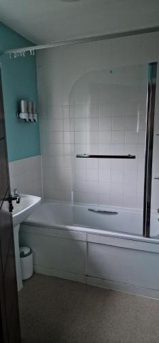 a white bathroom with a tub and a sink at J Lodge in Northampton