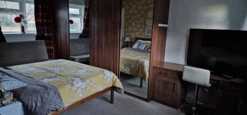 a bedroom with a bed and a flat screen tv at Pleasant Lodge in Northampton
