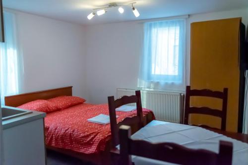 a bedroom with a red bed and a window at Gora Apartments Premium Lodge - Stara Planina in Balta Berilovac