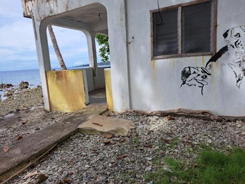 an abandoned building with drawings on the side of it at Paseo Del Mar Seaside Inn in Jagna
