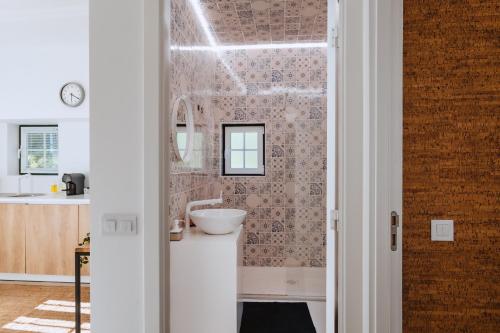 ein Bad mit einem Waschbecken und einem Spiegel in der Unterkunft Encosta d´Óbidos in Óbidos