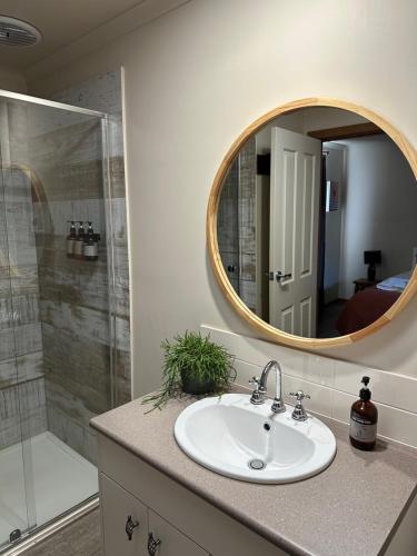 W łazience znajduje się umywalka i lustro. w obiekcie Daysend Cottages w mieście Merrijig
