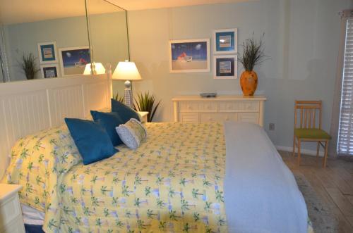 a bedroom with a large bed with blue pillows at Gulf front condo in Panama City Beach