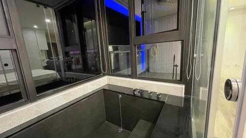 een badkamer met een douche en een wastafel met spiegels bij 宜蘭頭城鎮 Alice 高級溫泉雙-四人套房海景度假 in Hsin-hsing