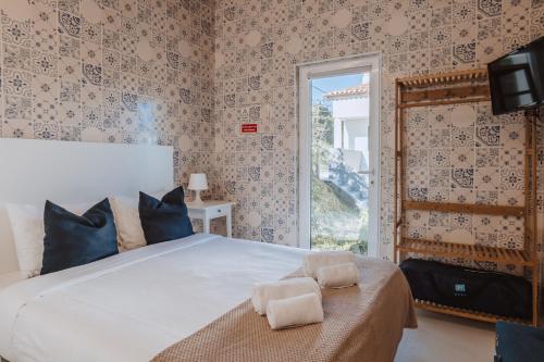 a bedroom with a large bed and a window at Encosta d´Óbidos in Óbidos