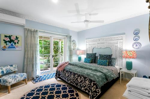 a blue bedroom with a bed and a window at Noosa Valley Manor B&B in Doonan
