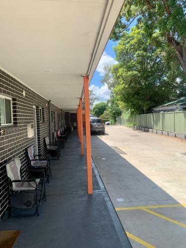 a building with tables and chairs on a sidewalk at Singleton Valley Accommodation in Singleton
