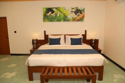 a bedroom with a large bed with blue pillows at NATURALIZA in Sigiriya