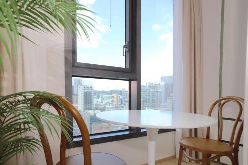 Una mesa y sillas en una habitación con ventana. en Apartment THE SHARE Myeongdong, en Seúl