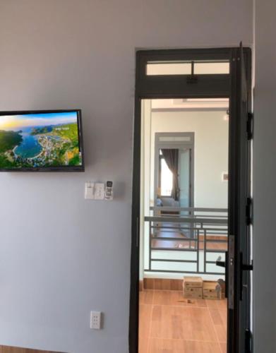 a door leading to a balcony with a painting on the wall at Nomad Stay in Phan Rang